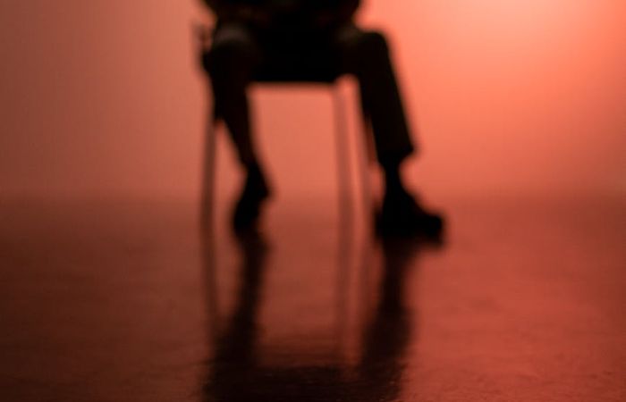 Silhouette of a man in a balancing pose against a warm, glowing background.